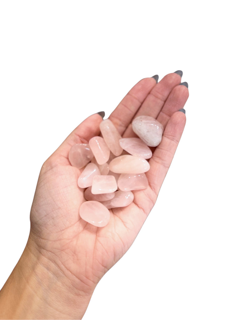 Polished pink rose quartz tumblestone, soft pink colour, hand sized for the pocket, on bone background.