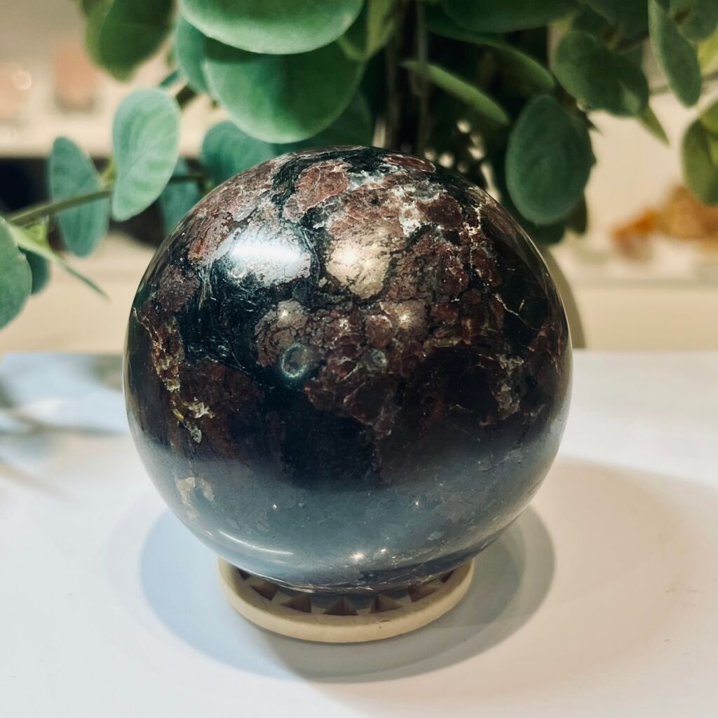 Almandine garnet sphere close view showing individual burgundy crystals and cream veining through the matrix