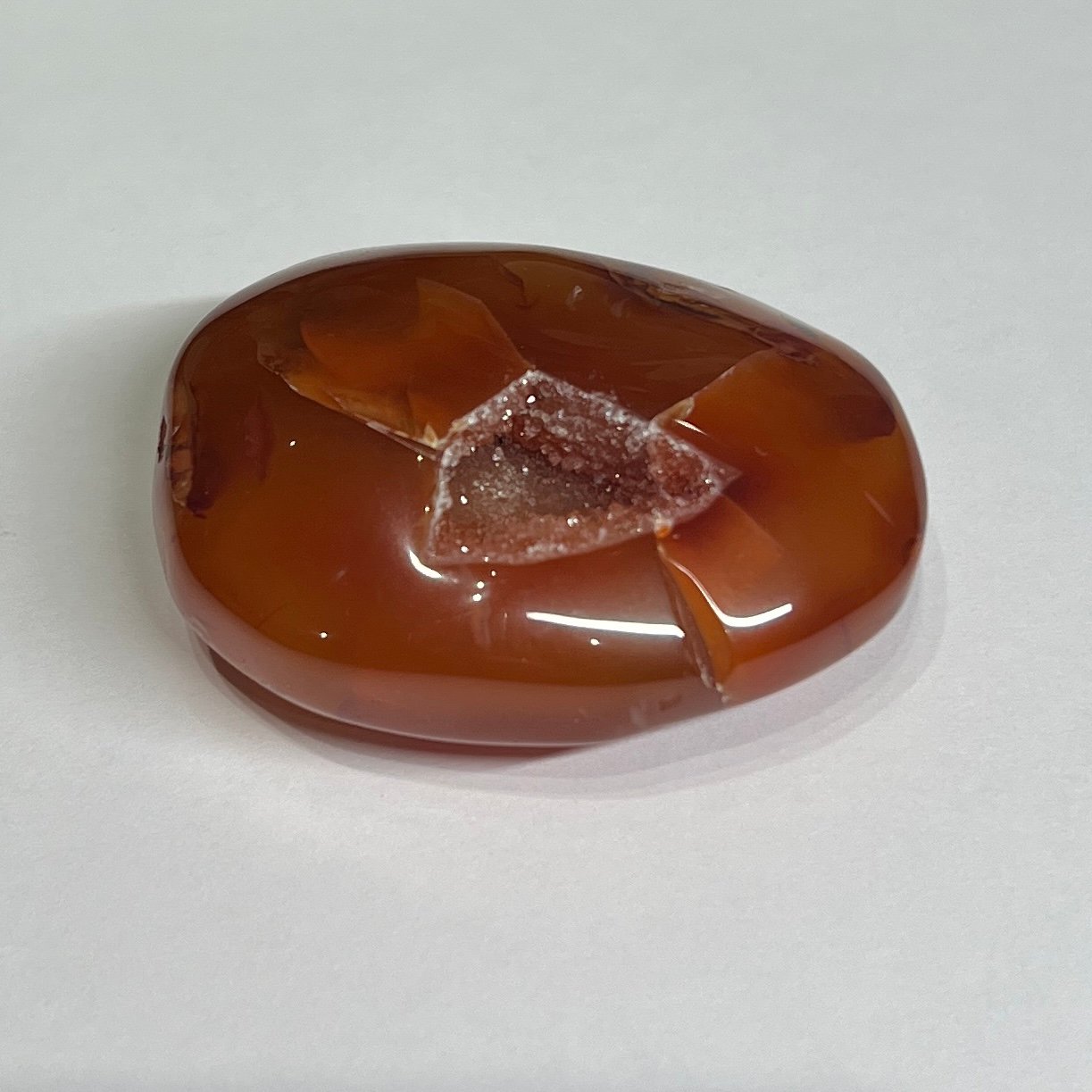carnelian druzy palm stone c Carnelian druzy palm stone C, amber orange with a shield shaped druzy pocket