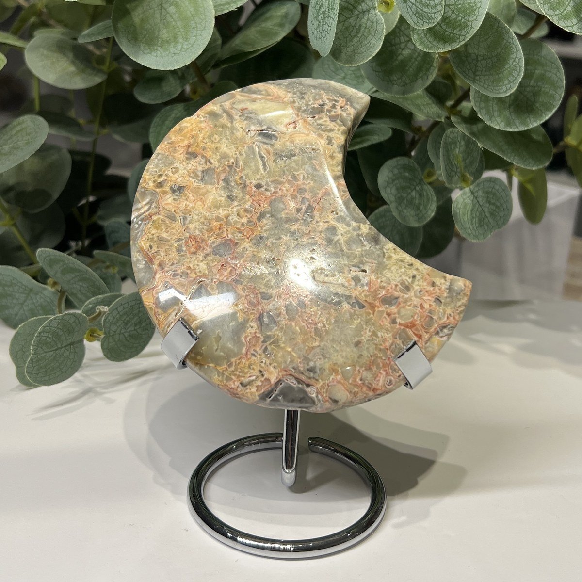 Crazy lace agate crystal moon E on a silver ring stand, 11cm Crazy lace agate crystal moon E on a silver ring stand, 11cm