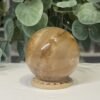 Golden Healer Quartz Sphere 63mm 2 Golden healer quartz sphere 63mm on wooden stand, view 2