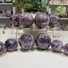 Dream amethyst spheres group, chevron amethyst crystal balls on wooden stands Dream amethyst spheres group, chevron amethyst crystal balls on wooden stands