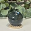 Labradorite Sphere 53mm Labradorite sphere 53mm on a wooden stand, dark grey green with blue flash, Mystic Grove UK
