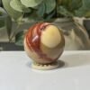 Mookaite Sphere C Red and cream mookaite sphere on a wooden stand