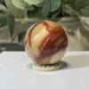 Mookaite Sphere C Red and cream mookaite sphere on a wooden stand