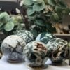 Five moss agate spheres on wooden stands