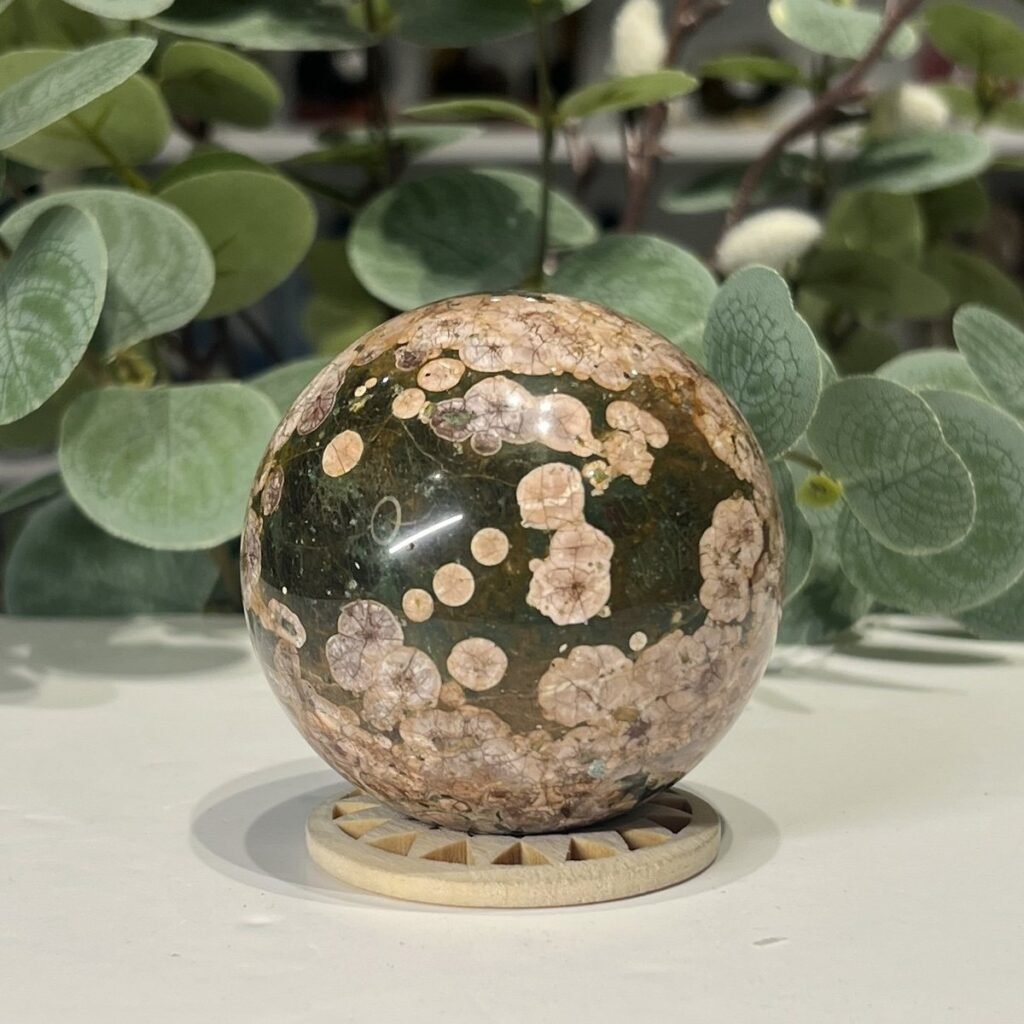 Ocean jasper sphere 63mm on a wooden stand, deep green with pink and cream orbs, Mystic Grove UK