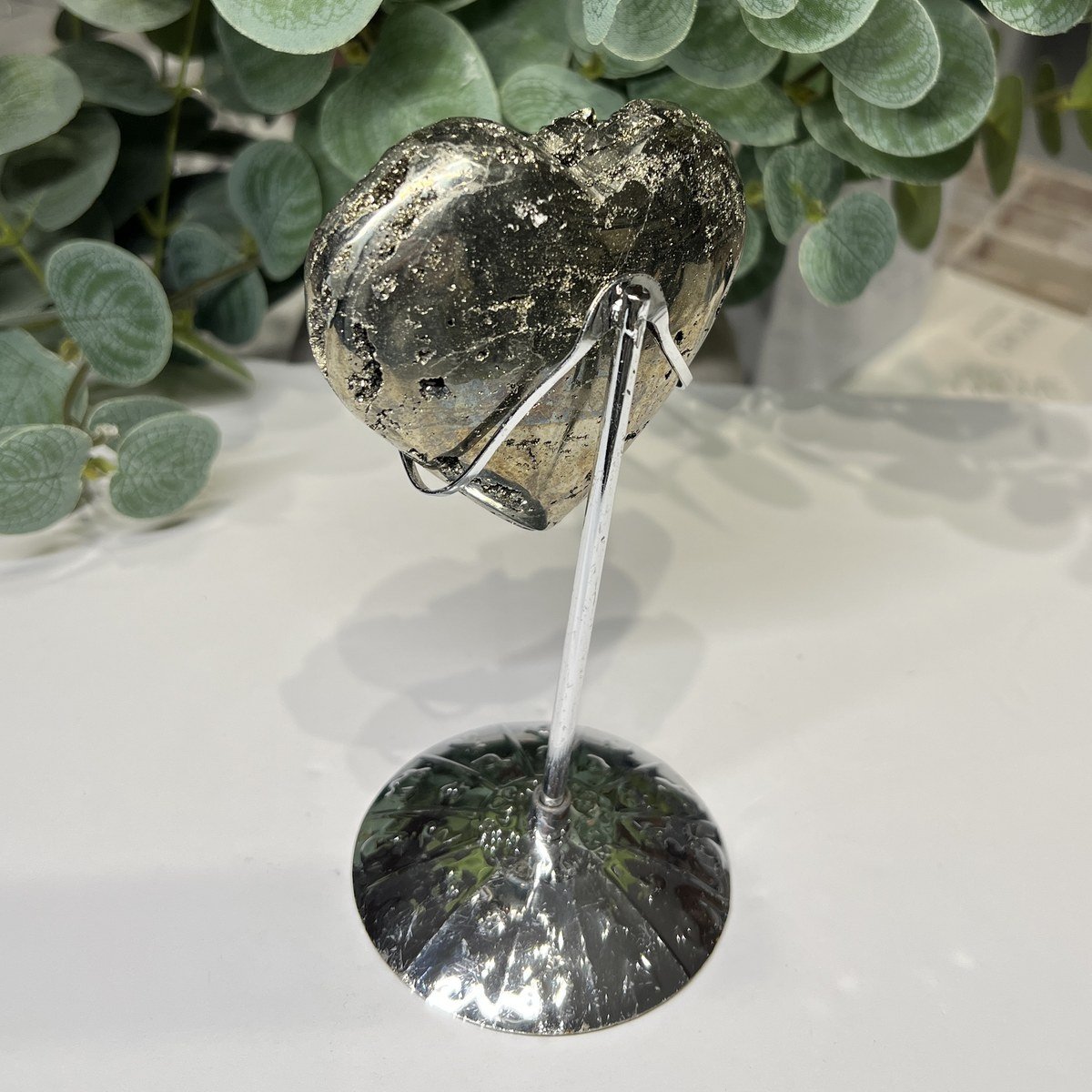 Pyrite heart on silver zodiac stand from above Pyrite heart on silver zodiac stand from above