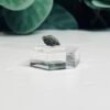 Raw moldavite A1 0.26g Czech tektite from the Chlum sand mine on a clear stand
