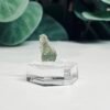 Raw moldavite A3 0.51g Czech tektite from the Chlum sand mine on a clear stand