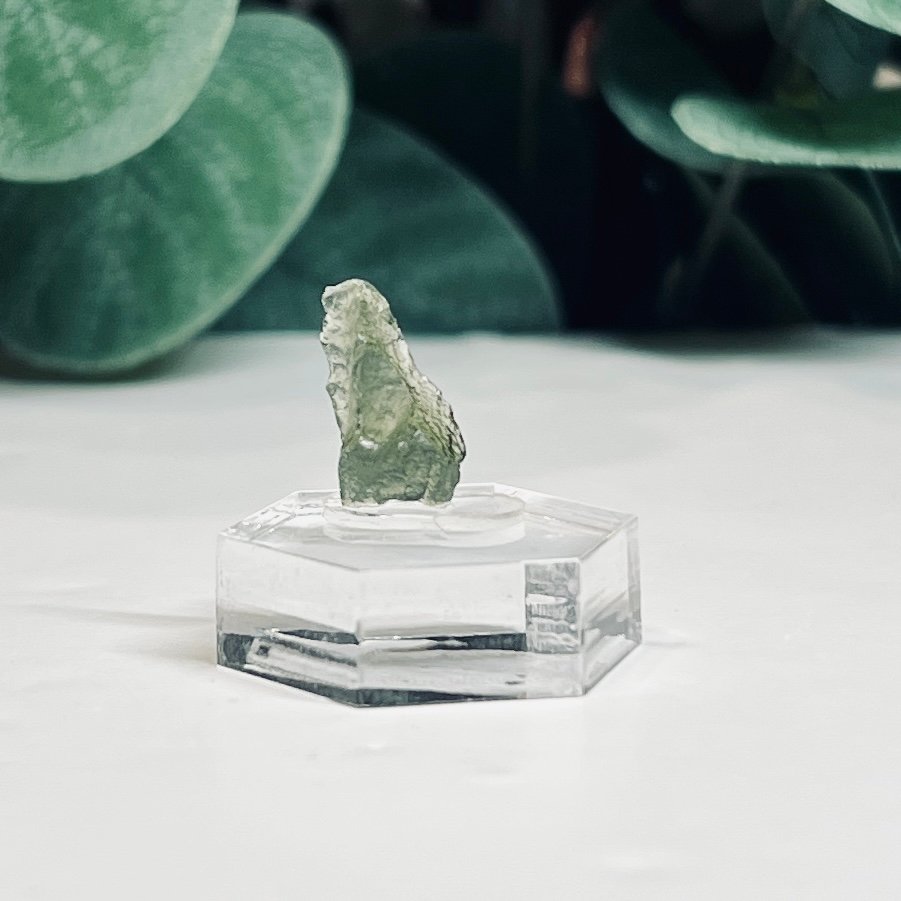 Raw moldavite A3 0.51g Czech tektite from the Chlum sand mine on a clear stand