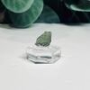 Raw moldavite A5 0.69g Czech tektite from the Chlum sand mine on a clear stand