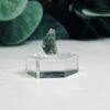 Raw moldavite A6 0.70g Czech tektite from the Chlum sand mine on a clear stand