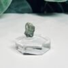 Raw moldavite B3 0.58g Czech tektite from the Chlum sand mine on a clear stand
