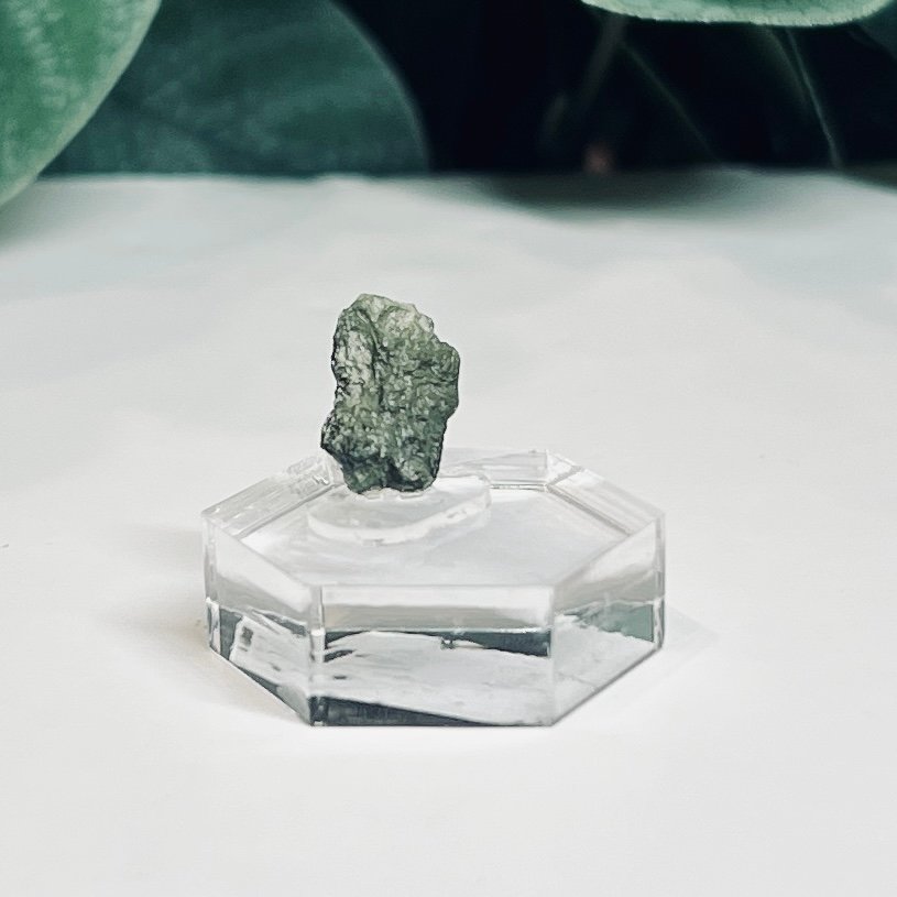 Raw moldavite B3 0.58g Czech tektite from the Chlum sand mine on a clear stand