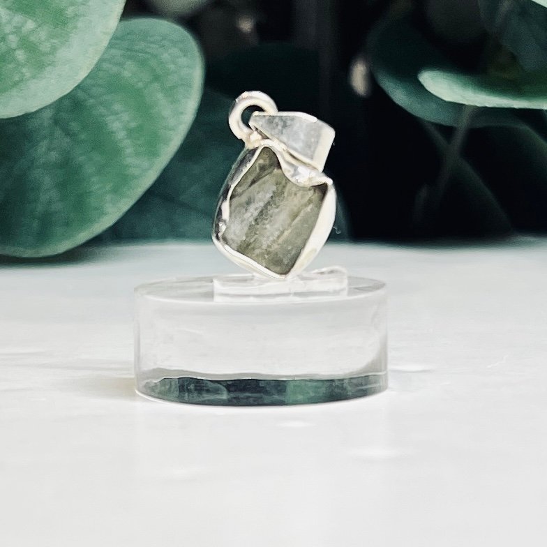 Raw moldavite C1 0.45g Czech tektite from the Chlum sand mine on a clear stand