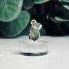 Raw moldavite pendants set in sterling silver on clear stands