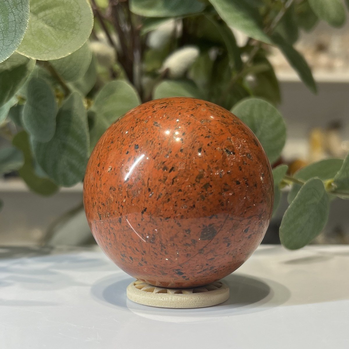 Red jasper sphere A Red jasper sphere A, 63mm, brick red with dark speckles, on a wooden stand