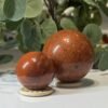 Two red jasper spheres on wooden stands Two red jasper spheres on wooden stands