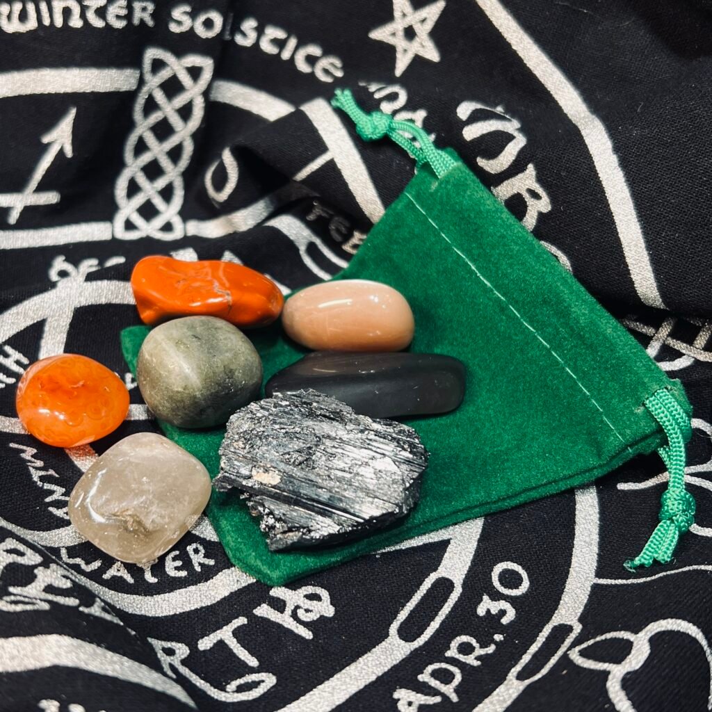 Samhain crystal set of seven tumblestones, obsidian, black tourmaline, smoky quartz, labradorite, moonstone, carnelian and red jasper, with a green velvet pouch