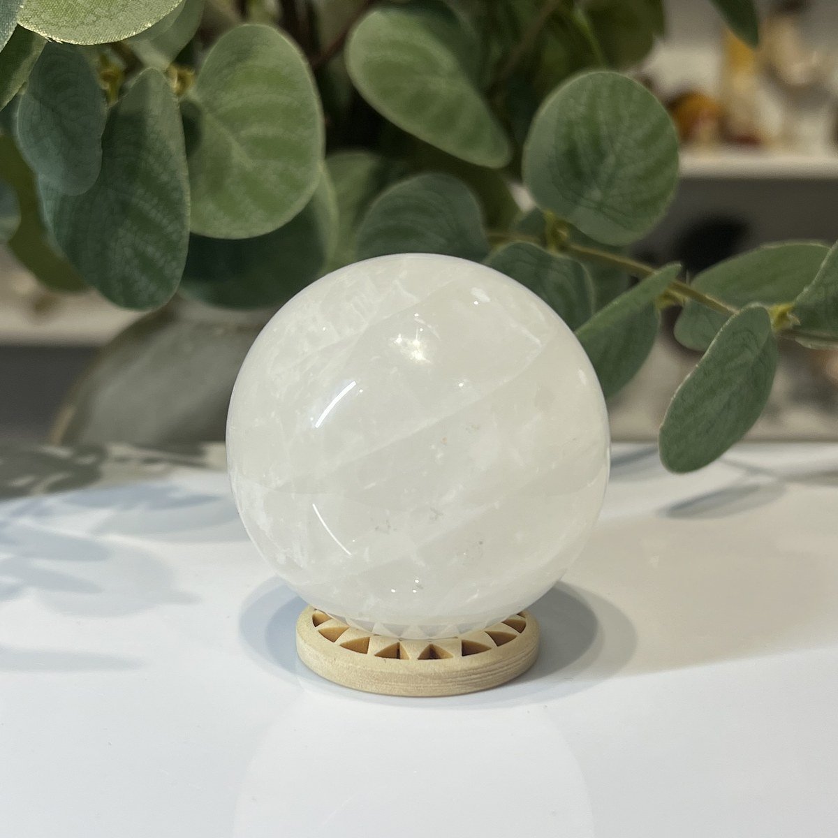 Snow quartz sphere B Snow quartz sphere B, 52mm, milky white, on a wooden stand