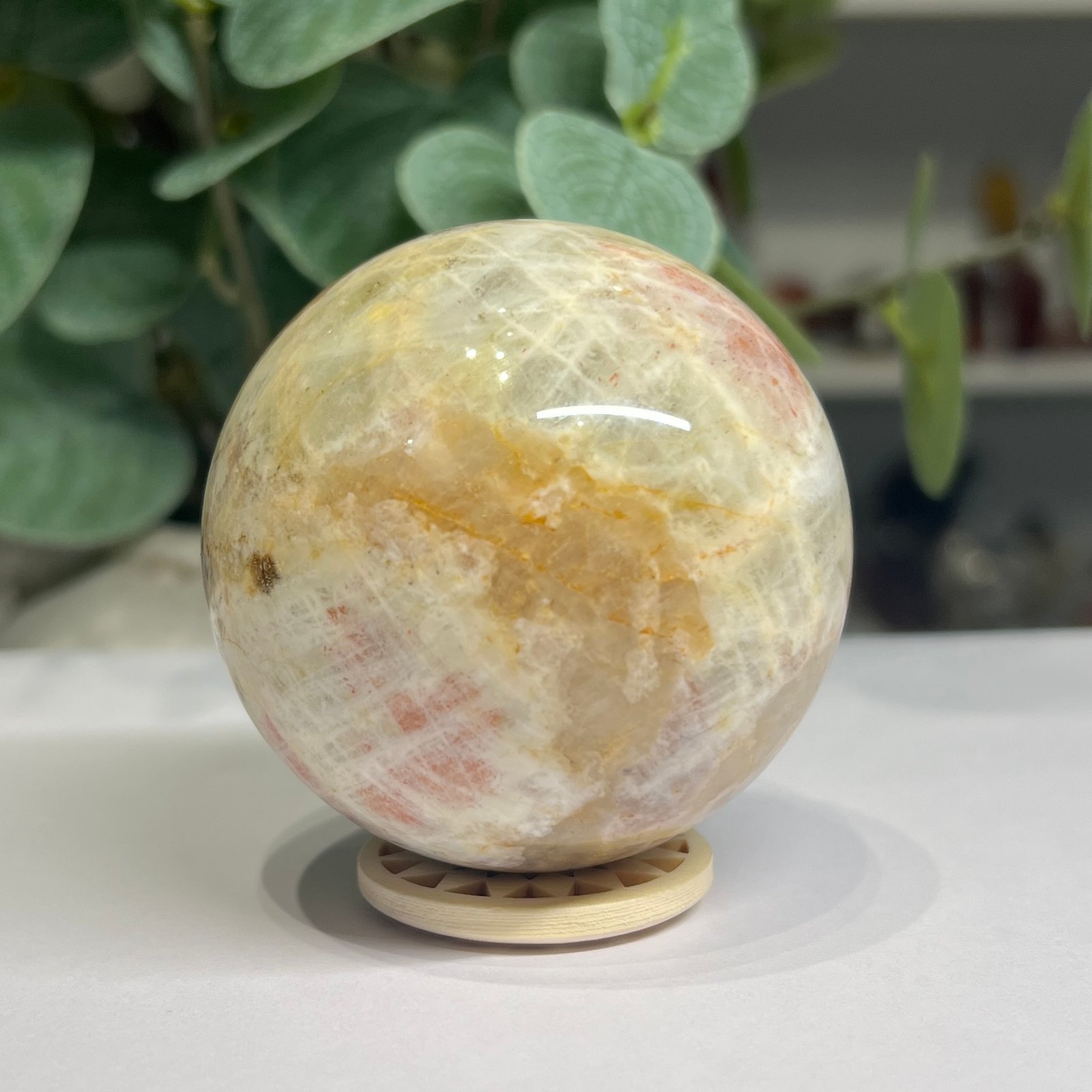 sunstone sphere 6cm Sunstone sphere 6cm, cream feldspar with peach sunstone and golden veining, on a wooden sphere stand