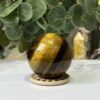 Tigers eye sphere A, 55mm, on wooden stand Tigers eye sphere A, 55mm, on wooden stand