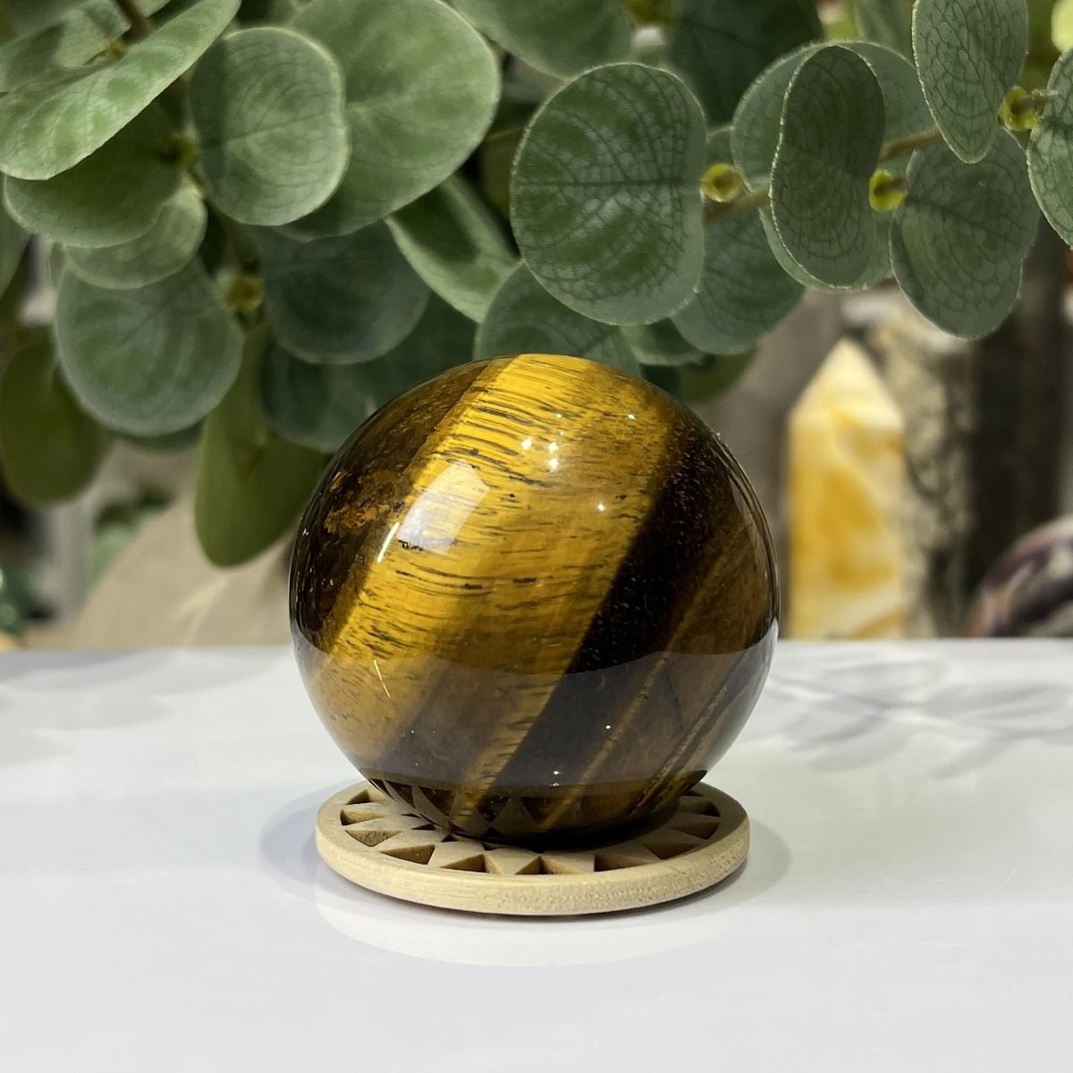 Tigers eye sphere A, 55mm, on wooden stand Tigers eye sphere A, 55mm, on wooden stand