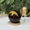 Tigers eye sphere B, 51mm, on wooden stand Tigers eye sphere B, 51mm, on wooden stand