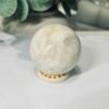 white moonstone sphere 5cm 202g White moonstone sphere 5cm, milky white with soft grey shadows, on a wooden sphere stand