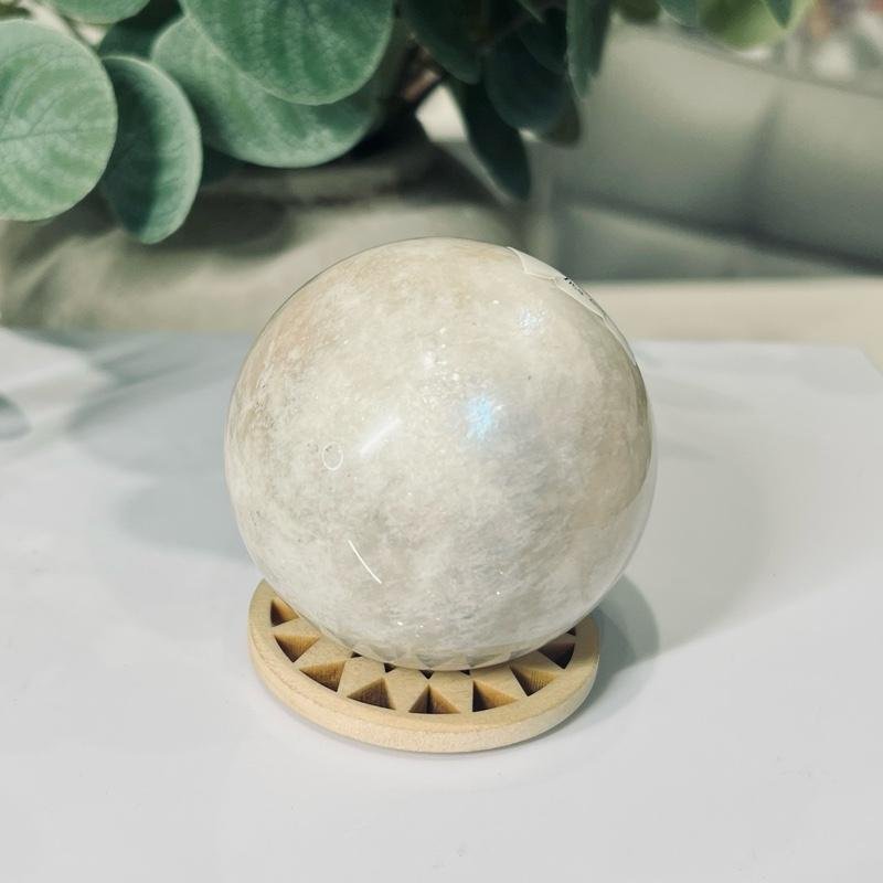 white moonstone sphere 6cm 276g White moonstone sphere 6cm, soft cream and pale grey with a gentle sheen, on a wooden sphere stand